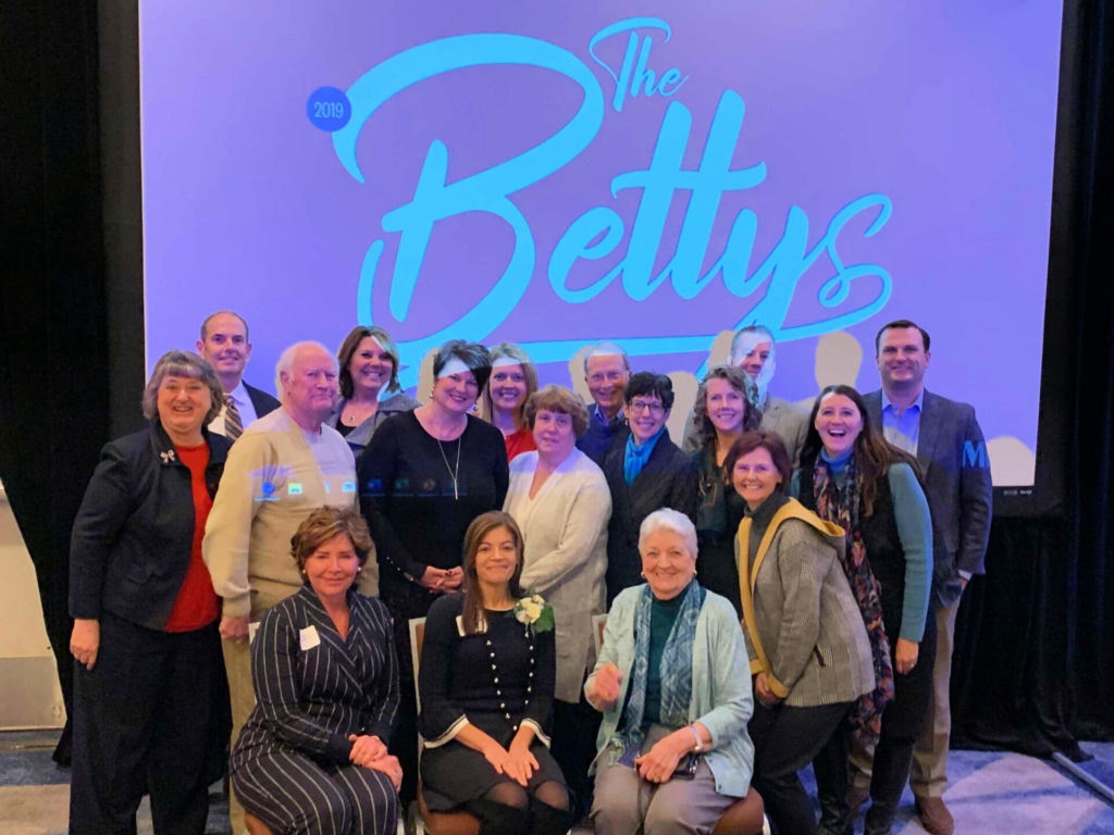 Representatives from Kathy's House pose in front of the Betty Awards logo
