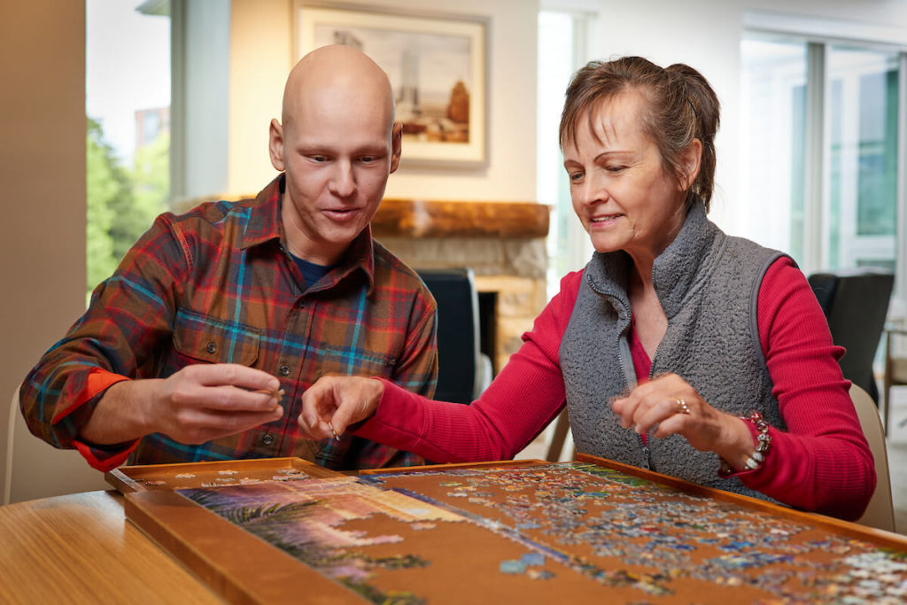 Sam and his mother, Rebecca, work on a puzzle inside Kathy's House.